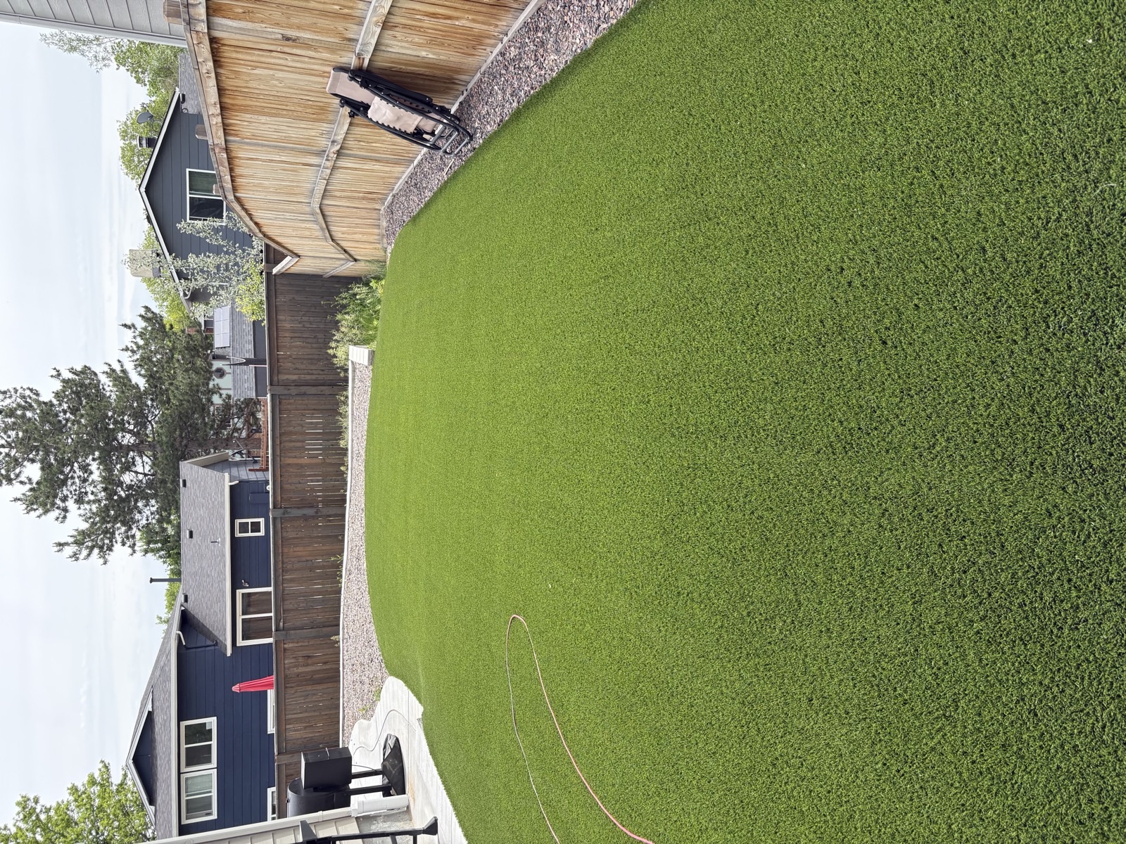 Clean artificial turf lawn after professional maintenance in a Colorado backyard